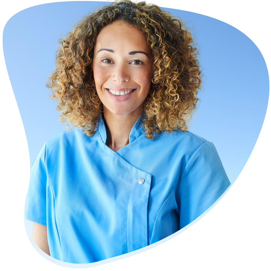 A woman with curly hair wearing a blue uniform stands confidently, smiling at the camera.